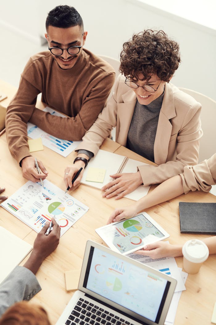 About A diverse team of professionals collaborating over charts and graphs during a business meeting.