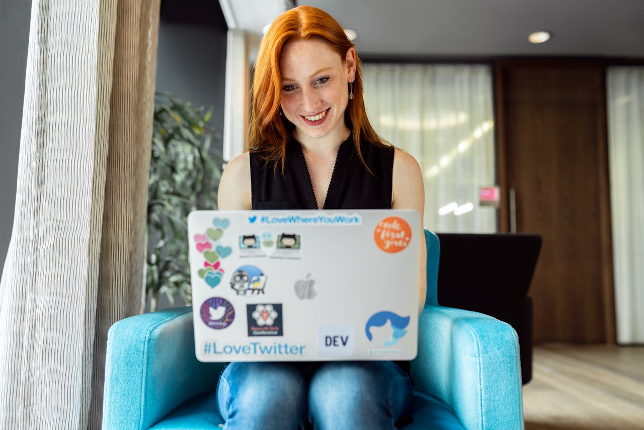 Services Smiling woman engaged in remote work on a laptop at home office setting.